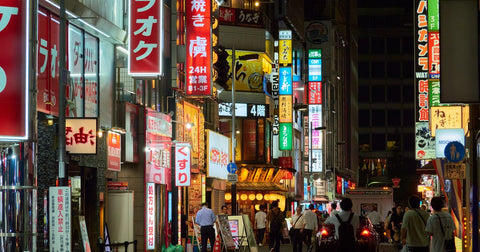 Neon-lit shopping street in Shinjuku, Tokyo at night